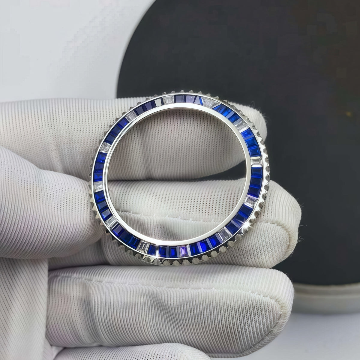 A jeweler inspecting a finished gemstone bracelet while wearing white gloves.