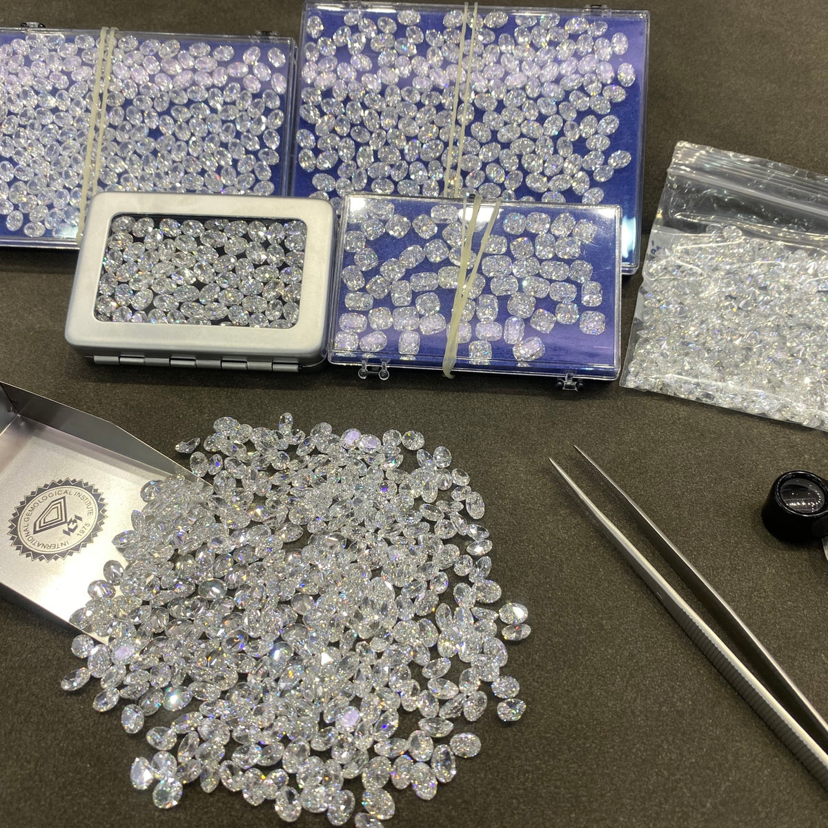 Loose diamonds, grading tools, and tweezers prepared for selection.